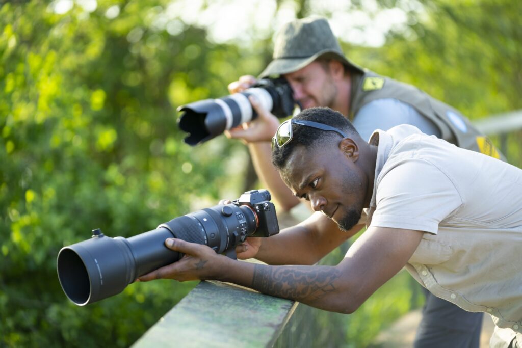 To menn fotograferer med store kameralinser