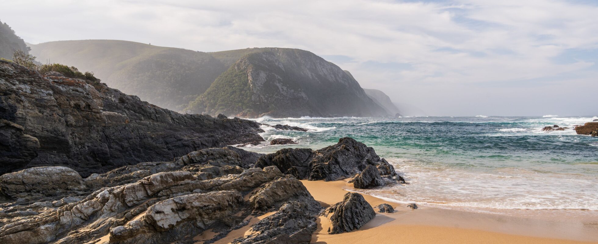 Stenete strandlandskap i Tsitsikamma nasjonalpark, Sør-Afrika