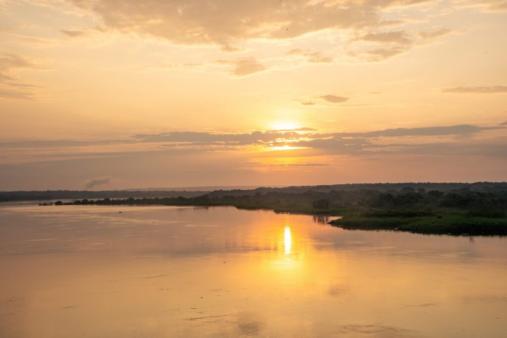 Solen farger himmelen oransje og reflekteres på Nilen i Uganda.
